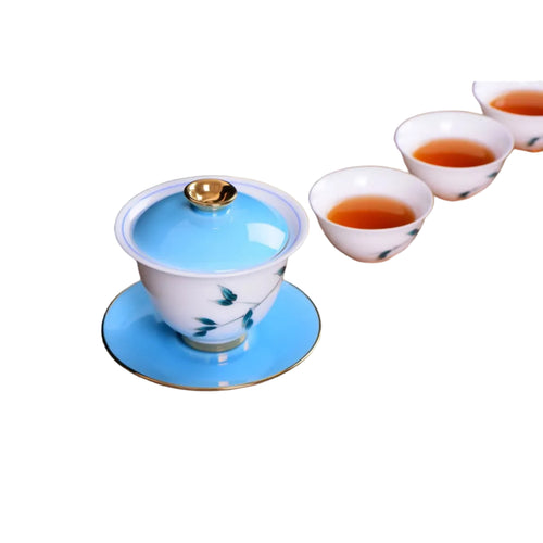 Blue bamboo porcelain gaiwan with matching tea cups during tea brewing