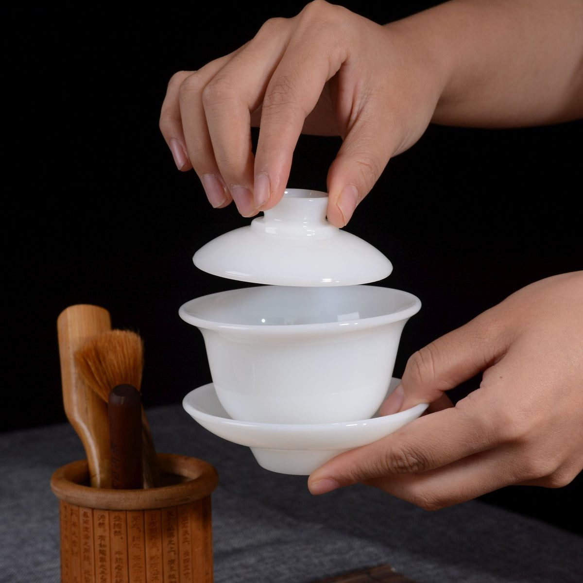Dehua jade porcelain gaiwan shown with the lid being lifted