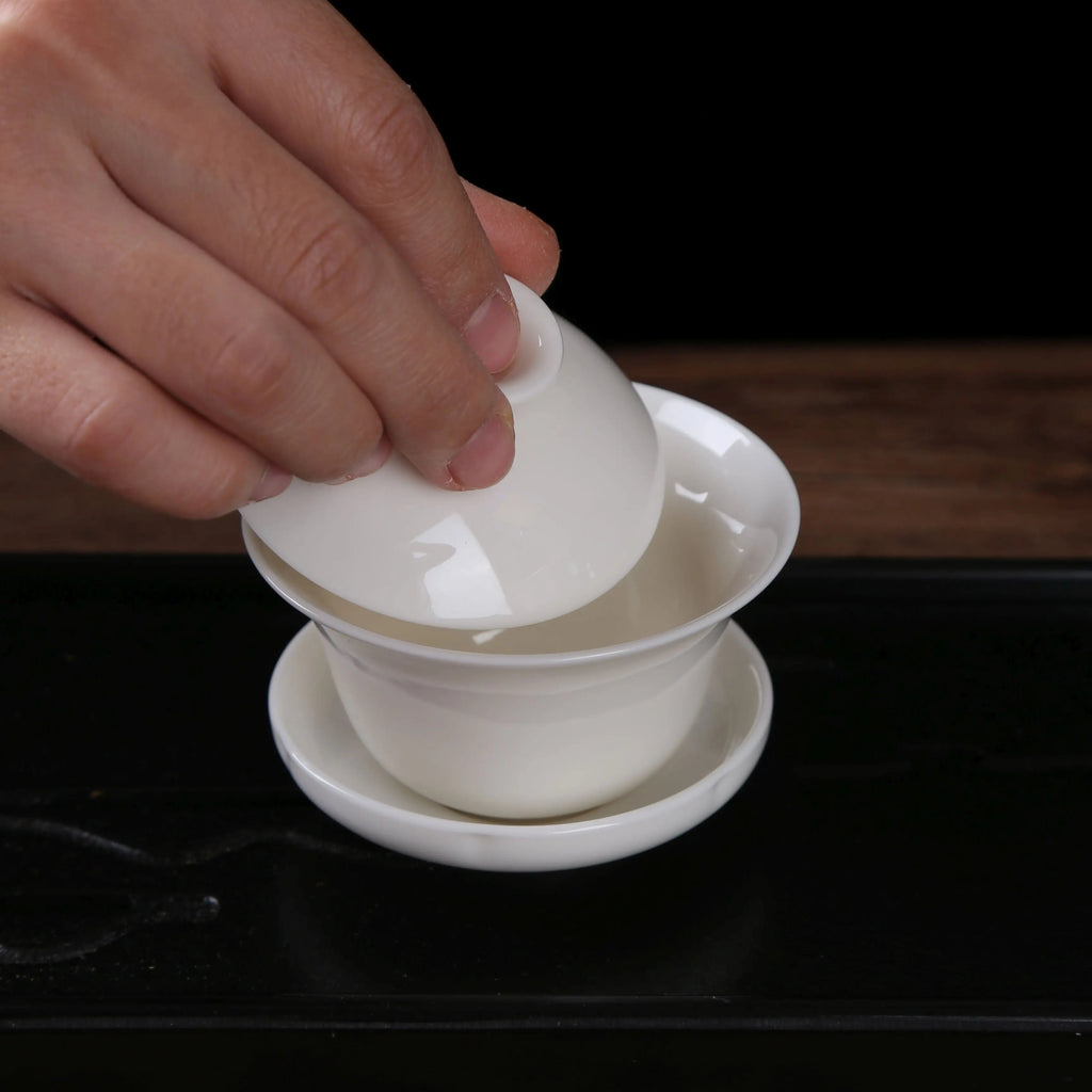 White porcelain gaiwan with lid opened for gongfu tea brewing